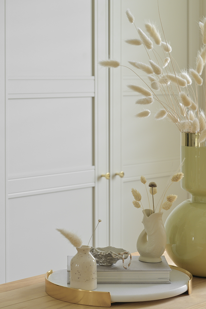 interior photo of vases with dried flowers in front of wardrobe